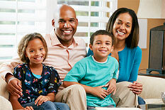 a mother and father and two young children smiling at the camera