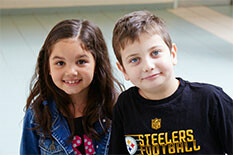 a girl and a boy smiling at the camera