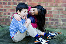 a student comforting another student who has hurt his knee