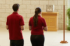 two students praying in a church